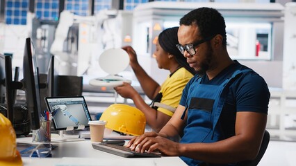 African american industrial technician assesses system health in solar facility, using software...