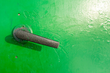 door handle and lock on green metal door, close up