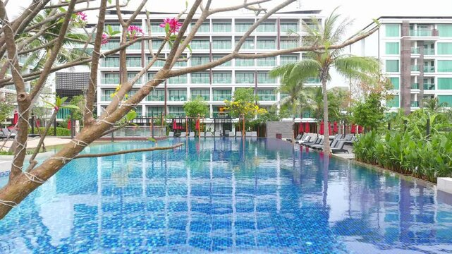 Tropical Resort Swimming Pool with Building and Lush Greenery