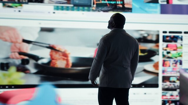 Happy person typing on phone touchscreen, relaxing with curated digital content. Joyous man browsing social media apps on smartphone in front of interactive dashboard in modern setting, camera A