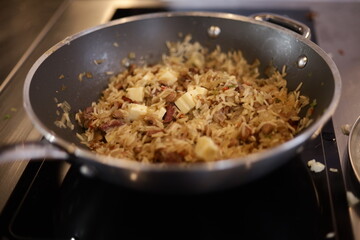 Detalhe do preparo do Baião de Dois — prato típico do Nordeste brasileiro que une arroz,...