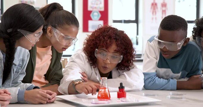 Multiracial students and female teacher in science class observing chemical reaction, at school