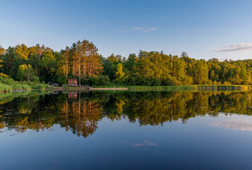 Fototapeta premium A little canoe shack on the banks of Hartley pond at the center of Hartley Nature Area in Duluth, Minnesota on a calm summer evening