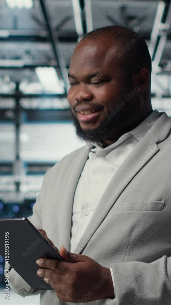 Poster vertical video engineer working in server farm using tablet to analyze data. it professional examini