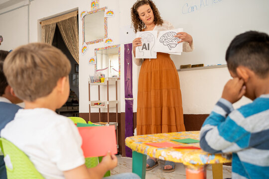 Preschool teacher compares human brain and AI using illustrated cards during a class. Children explore differences between natural and artificial intelligence in a fun, educational activity