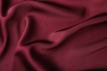 Crumpled burgundy silk fabric as background, top view