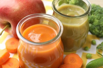 Baby food. Tasty puree in glass jars and ingredients on table, closeup