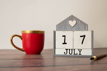 July 17 calendar date text on wooden blocks with blurred background park