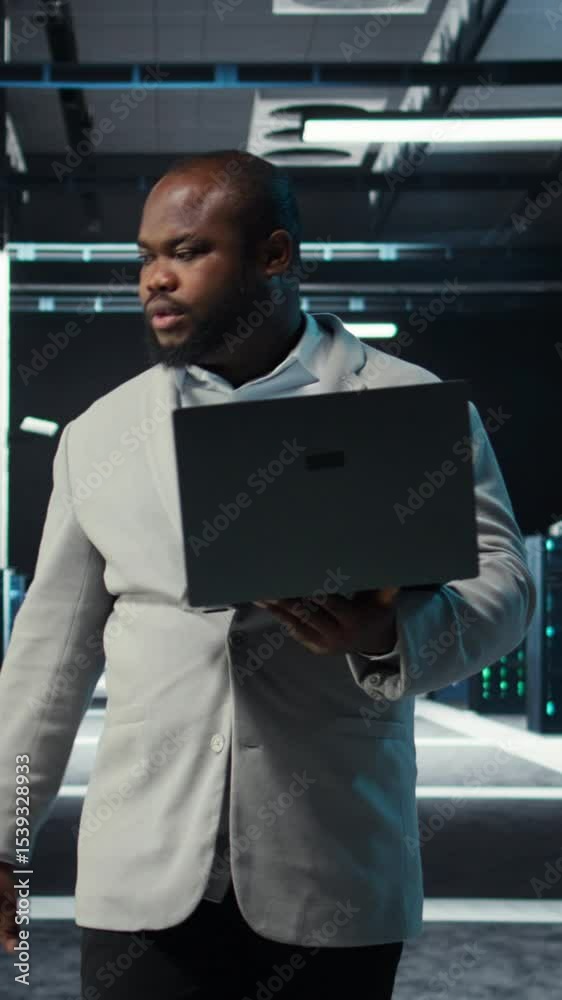 Poster vertical video data center system administrator coding on laptop, doing software updates. server roo