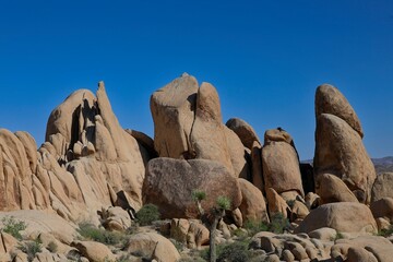 Interesting rock formations and stacks of boulders bake in the desert sun in California's Joshua...