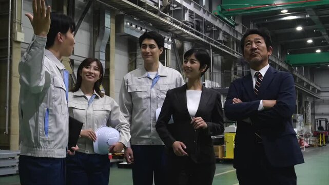 訪問者に工場を案内する作業員