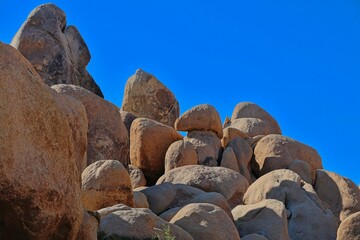 Interesting rock formations and stacks of boulders bake in the desert sun in California's Joshua...