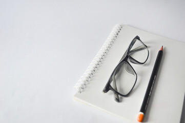 notebook, pencil and glasses isolated on white background