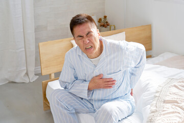 胸が痛いパジャマを着た中年の男性