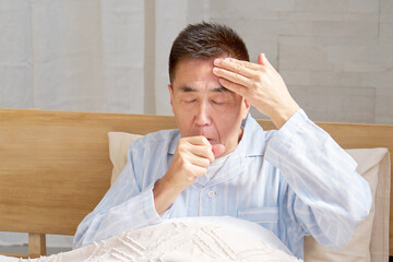 咳をするパジャマを着た中年の男性