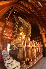 Golden sitting Buddha statue and there is a serpent covering the back in Buddhist Thai Church at Wat Den Sali Si Mueang Kaen temple. Located at Chiang Mai city in Thailand.