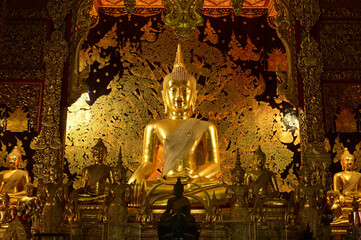 The golden sitting statue of Phra Kaew Klao Chao Bun Rueang Buddha is enshrined in a teakwood chapel at Wat Den Sali Si Mueang Kaen temple or Wat Ban Den. Located at Cheng Mai Province in Thailand.