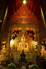 The golden sitting statue of Phra Kaew Klao Chao Bun Rueang Buddha is enshrined in a teakwood chapel at Wat Den Sali Si Mueang Kaen temple or Wat Ban Den. Located at Cheng Mai Province in Thailand.