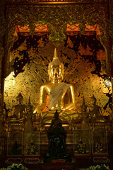 The golden sitting statue of Phra Kaew Klao Chao Bun Rueang Buddha is enshrined in a teakwood chapel at Wat Den Sali Si Mueang Kaen temple or Wat Ban Den. Located at Cheng Mai Province in Thailand.