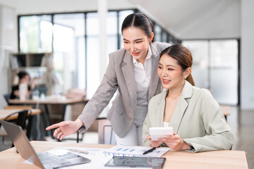 Working together on project. Two young business colleagues working on computer together in office.