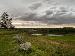 A Serene and Beautiful Landscape Showcasing Cloudy Skies Next to a Picturesque River View