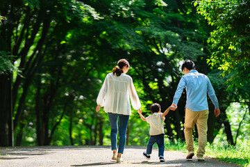 手を繋いで歩く家族の後ろ姿