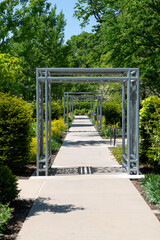 Modern metal garden arches forming a symmetrical pathway in a green park