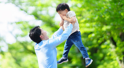 Fototapeta premium 5歳の息子を持ち上げる父親