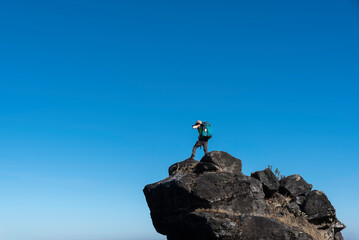 Hiker who hikers enjoys a break look at the top of the mountain at sunset adventure travel.