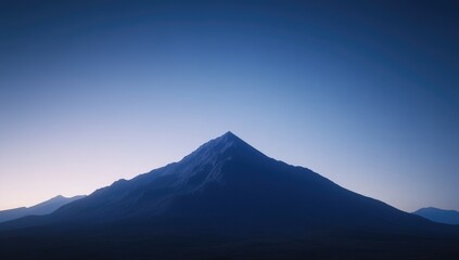 Silhouetted mountain peak against a gradient twilight sky