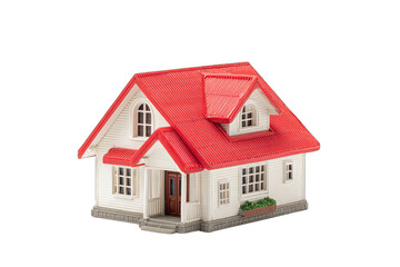 A small, detailed model house with a red roof, white walls, and small windows, sits against a plain black background.  It features a simple front porch and small landscaping details