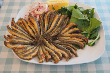 Crispy fried fish with fresh salad and lemon slices