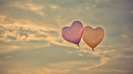 Fototapeta premium Two heart balloons in pastel sky, love in the air