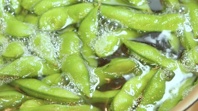 夏野菜の枝豆をお湯で茹でている動画。クローズアップ。