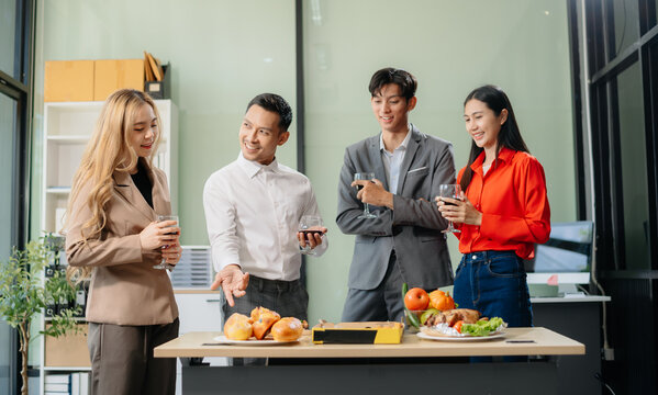 Young Asian Professionals Celebrating with Pizza and Drinks in a Modern Office Setting