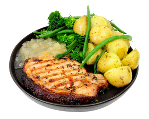 Pepper crusted pork loin steak meal with new potatoes and apple sauce isolated on a white background