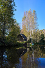 Tranquil Reflections: House and Trees Mirrored in River