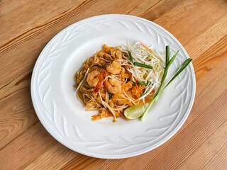 Phad Thai or Pad Thai, famous Thai stir fried noodles with sweet and spicy tamarind sauce with shrimps. Thai street food