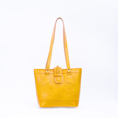 Beautiful yellow leather shoulder bag with embossed decoration for women isolated on white...
