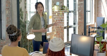 Diverse female team collaborating on software development project in modern office setting - Powered by Adobe