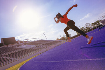 Fit young woman running sprinting at the racetrack. Fit runner fitness runner during outdoor workout at racetrack.