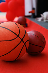 Basketballs on the ground. Close-up of a ball on a red court. Minimalism.