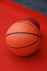 Basketballs on the ground. Close-up of a ball on a red court. Minimalism.
