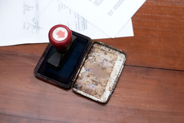 A stamp on a document approved certified contract, law and paperwork permit in the wooden table. 