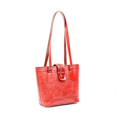 Beautiful red leather shoulder bag with embossed decoration for women isolated on white background,...