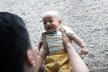 A Southeast asian father playing with baby boy in the home garden, doing everything together. Happy family 
