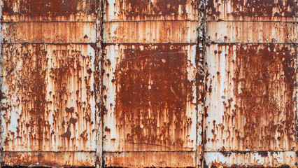 Severely rusted and weathered metal panels with vertical streaks, creating a grunge industrial...