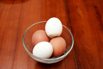 Bowl containing chicken boiled egg  on the kitchen table, prepares breakfast at home, health care and food concept. Copy space