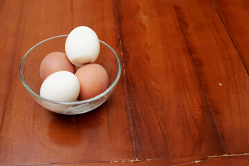 Bowl containing chicken boiled egg  on the kitchen table, prepares breakfast at home, health care and food concept. Copy space