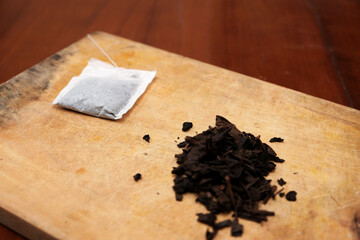 Tea bags and a bunch of loose tea in the wooden board. A quick and convenient way to brew tea.